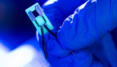 A small device is illuminated against a blue backdrop.