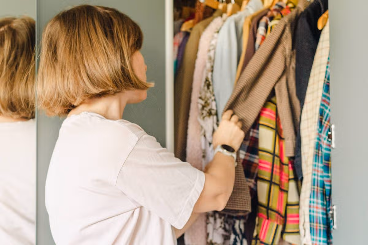 Young woman at home. sorting through and organizing her wardrobe