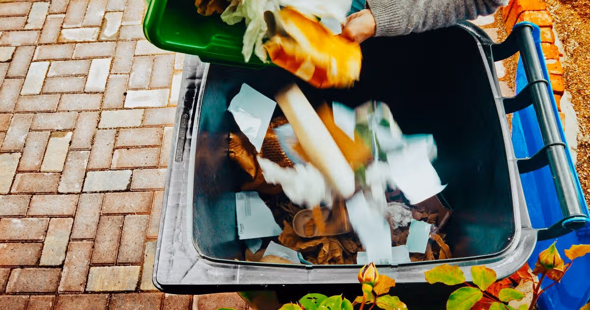 Senior woman recycling paper and cardboard items.
