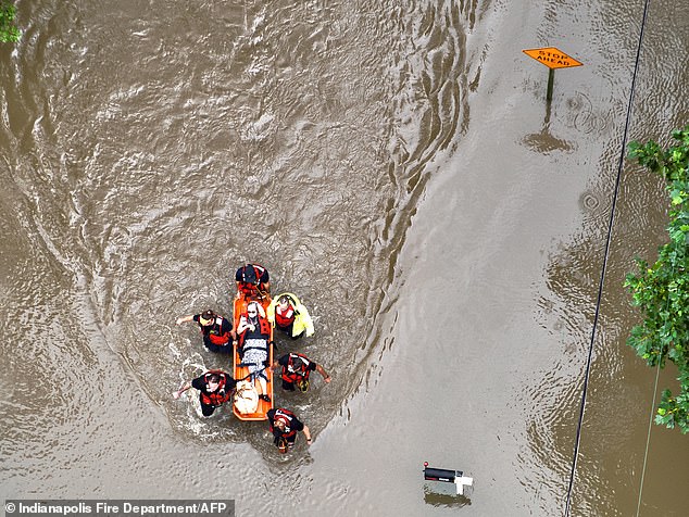 An injured resident is evacuated from raging floodwaters in the Indianapolis suburbs