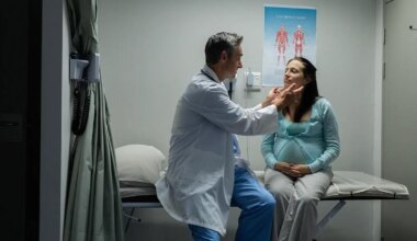 A photo of a male physician examining a pregnant woman.