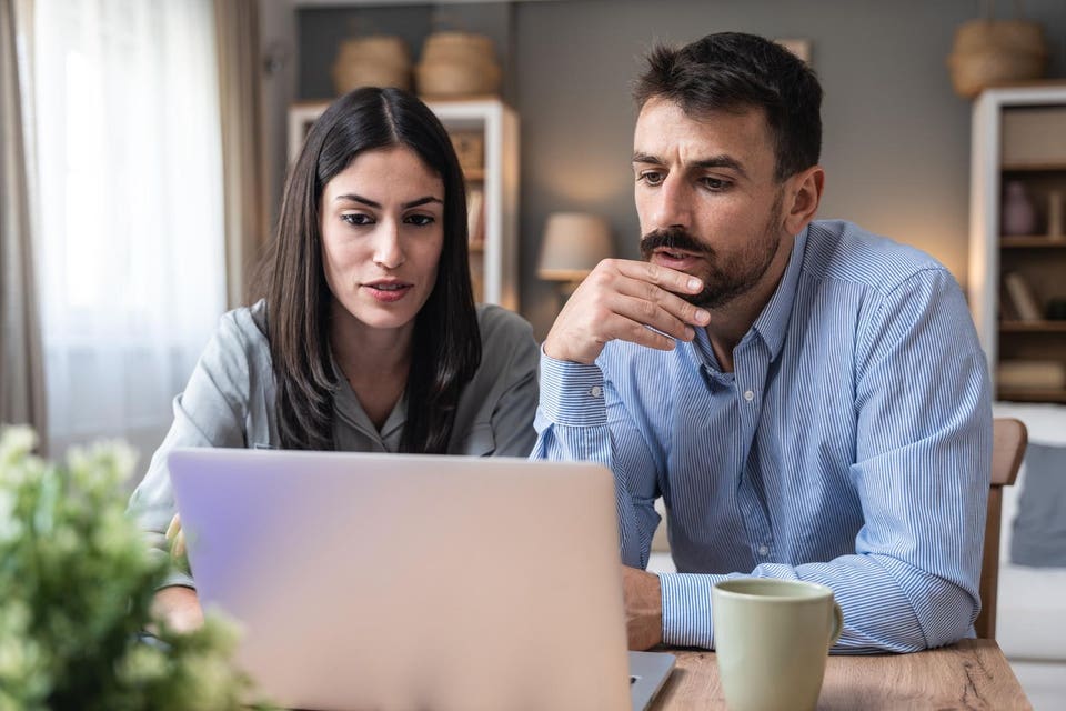 Successful young business people working together in home office. Couple teamwork startup concept video call presentation on laptop computer and webcam. Businessman and businesswoman working at home.