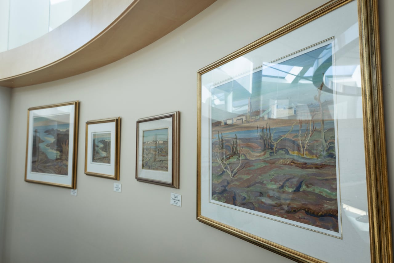 Four paintings hang on a wall