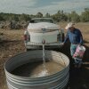 Mark Ragsdale refills a stock tank, July 17, 2026 in Redvale, Colo.