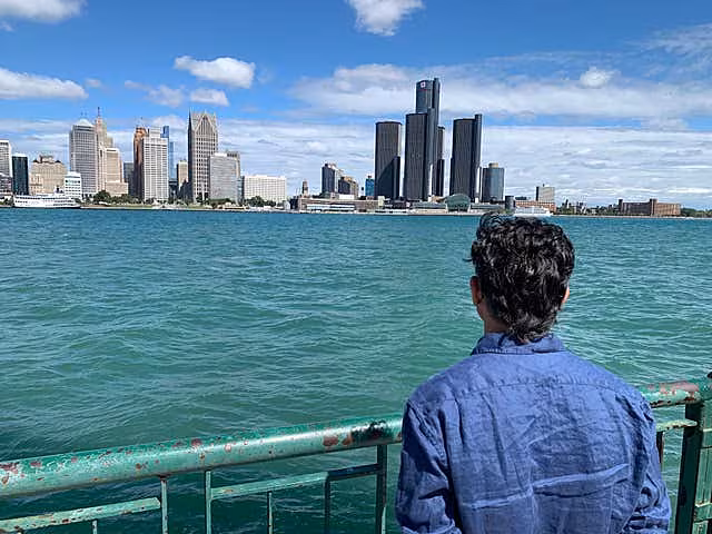 A person looks at the Detroit skyline across the Detroit River in Ontario