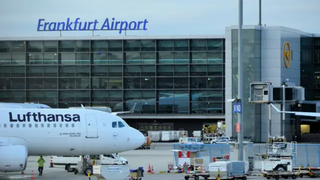 A view of a taxiing area at Frankfurt Airport. A Lufthansa plane sits on the tarmac. 