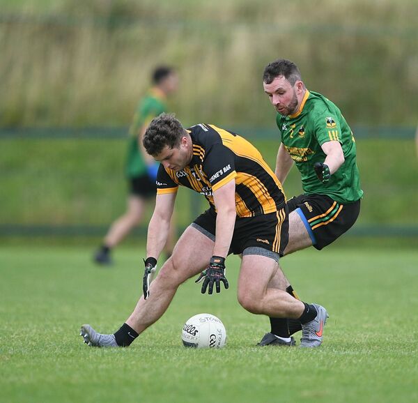 Strokestown forward Kevin Finn stoops to gather possession ahead of Michael Glaveys defender, Conor Ruane, during Sunday's senior football championship game in Enfield. Picture: Gerard O'Loughlin