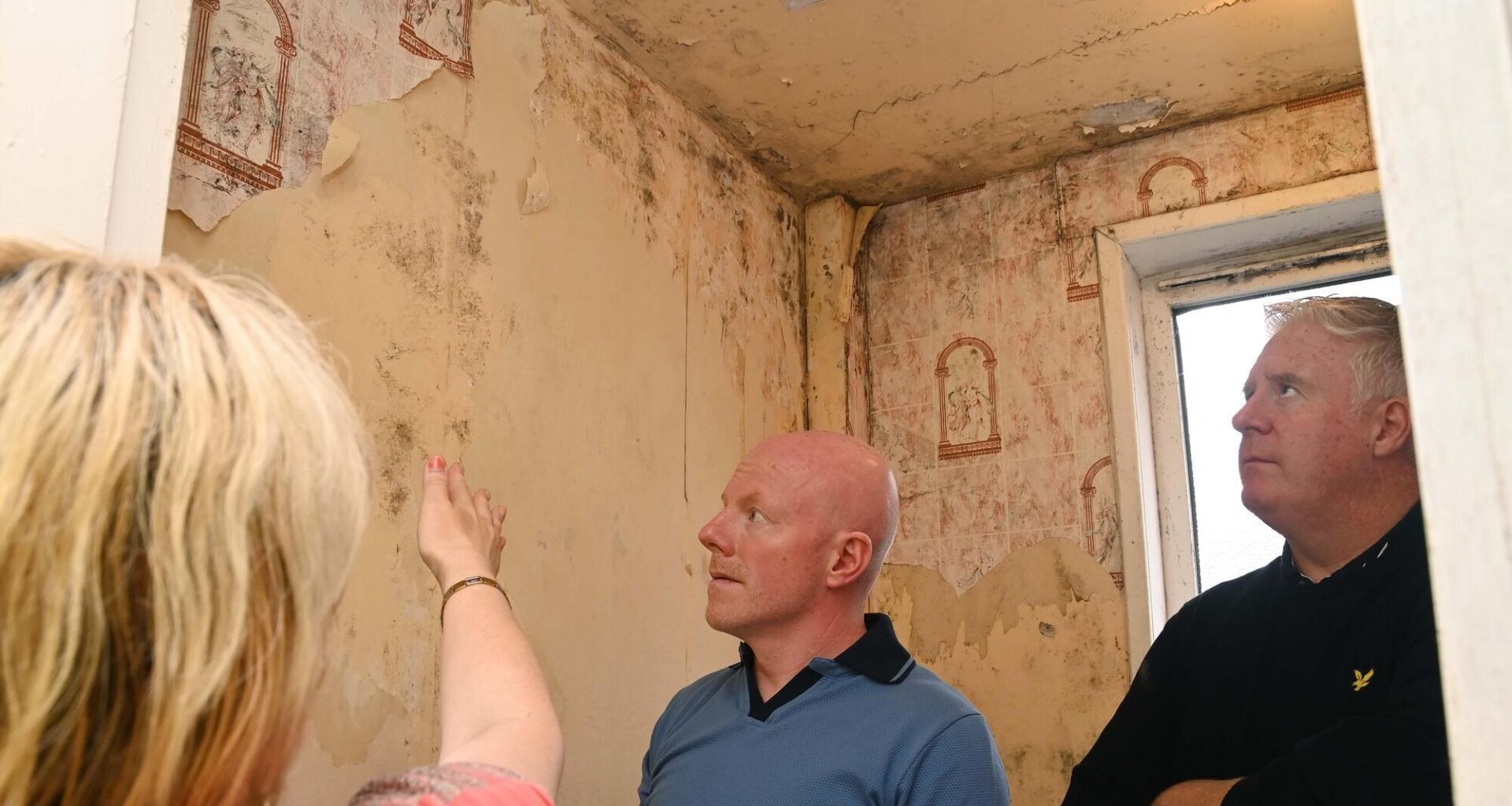 A tenant pointing out the mould and water damage from leaks in the bathroom in a flat at Noonan's Rd, to councillor Mick Finn (right) and community activist William O'Brien in 2023. File picture: Denis Minihane