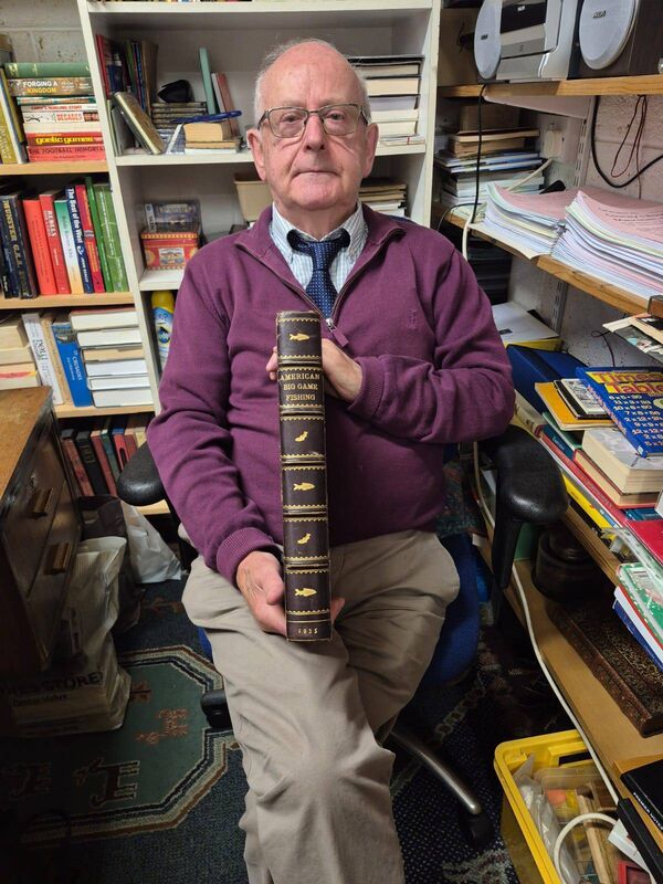 Jim Cooney with one of his rare books in his bookshop in Macroom