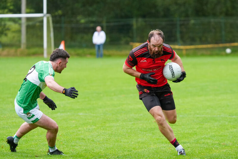 Ballingeary’s Cian Ó Duinnín avoids the challenge of Aghabullogue’s Paul Dilworth during their SAFC clash at Macroom. Picture: Noel Sweeney