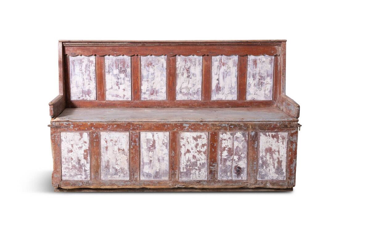 A red-and-white painted three-seater settle bench at James Adam.