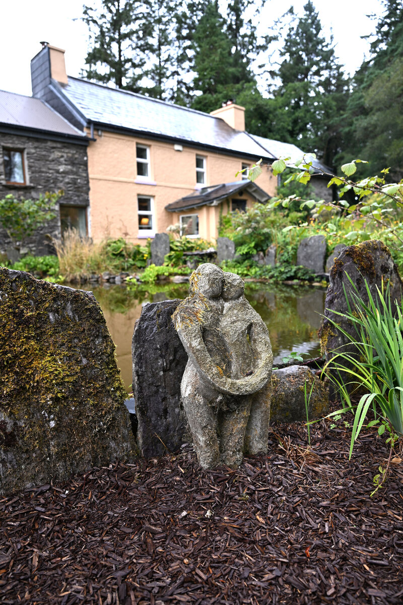 'Embracing couple' stone sculpture beside the pond