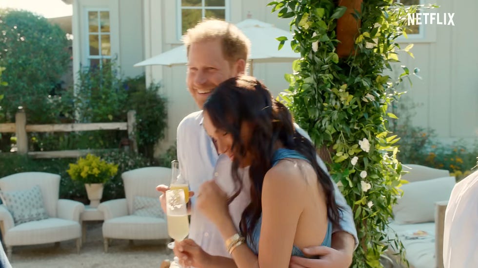 A couple sharing a joyful moment at a social gathering outdoors.