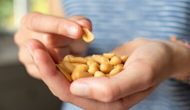 person holds out a handful of peanuts