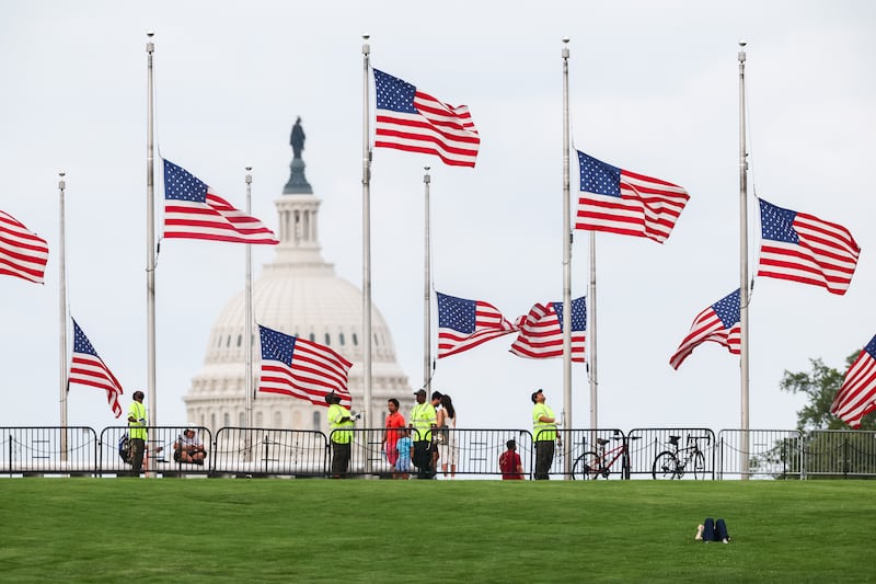 American flags being lowered to half mast by National Park Service staff around the Washington Monument following the announcement on Tuesday of Dolly Parton's death. Photograph: Finn Gomez/Getty Images