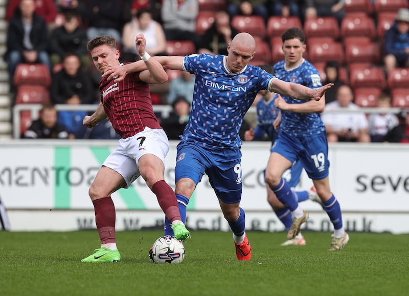 Georgie Kelly of Carlisle United challenges for the ball with Sam Hoskins of Northampton Town during the Sky Bet League One match between Northampton Town and Carlisle United at Sixfields in Northampton, England, on April 6th, 2024. Photograph: Pete Norton/Getty Images