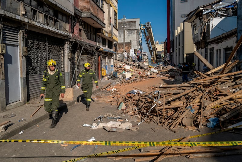 First responders walk down a rubble-strewn street  in Pereira, Colombia. Photograph: Juan Arredondo/New York Times
                      