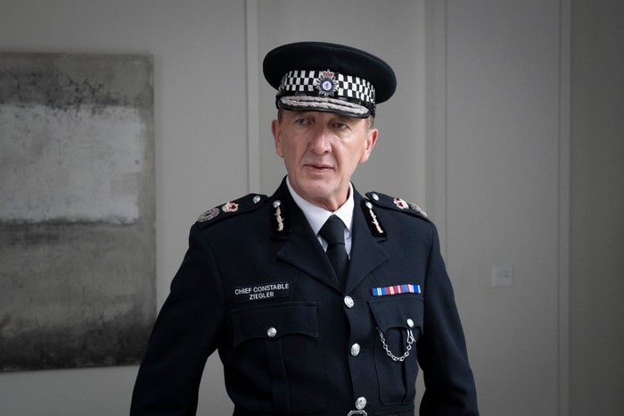 562847,TITLE:Ludwig - Series 2 Ralph Ineson as Chief Constable Ziegler in Ludwig, wearing a police uniform and cap.