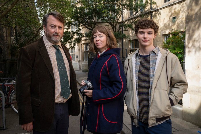 562852,TITLE:Ludwig - Series 2 David Mitchell as John "Ludwig" Taylor, Anna Maxwell Martin as Lucy Betts-Taylor and Dylan Hughes as Henry Betts-Taylor stand together on a leafy Cambridge street in Ludwig season 2.