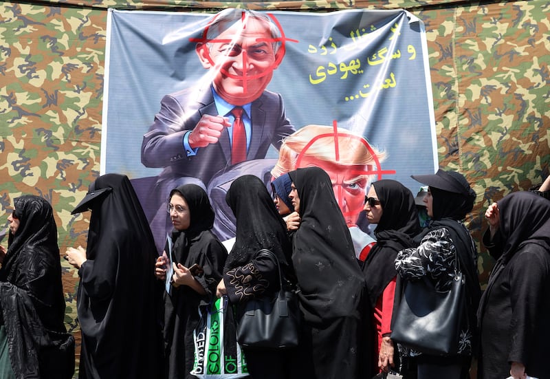 Shia Muslim devotees walk past a banner calling for revenge against US president Donald Trump and Israeli prime minister Binyamin Netanyahu during a mourning procession in Tehran on August 4th. Photograph: AFP via Getty Images