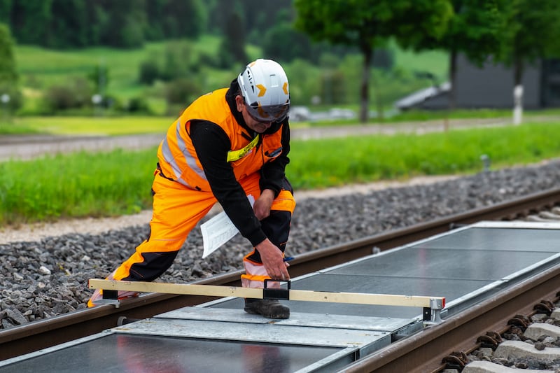 Solar panels being installed between rail tracks. 