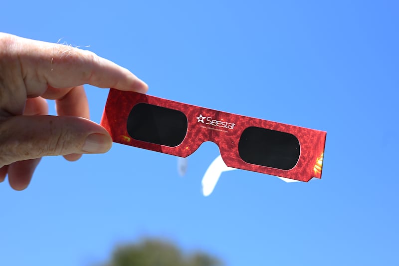 A member of the public holds up a pair of solar eclipse glasses prior to the partial eclipse. Photograph: Hugh Hastings/Getty Images