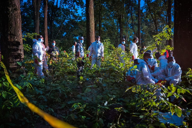 Police and army personnel wearing hazmat suits bury unidentified bodies recovered from the floods at a mass burial site in the Devghat Forest on in Bharatpur, Nepal, on Sunday. Photograph: Ezra Acayan/Getty Images