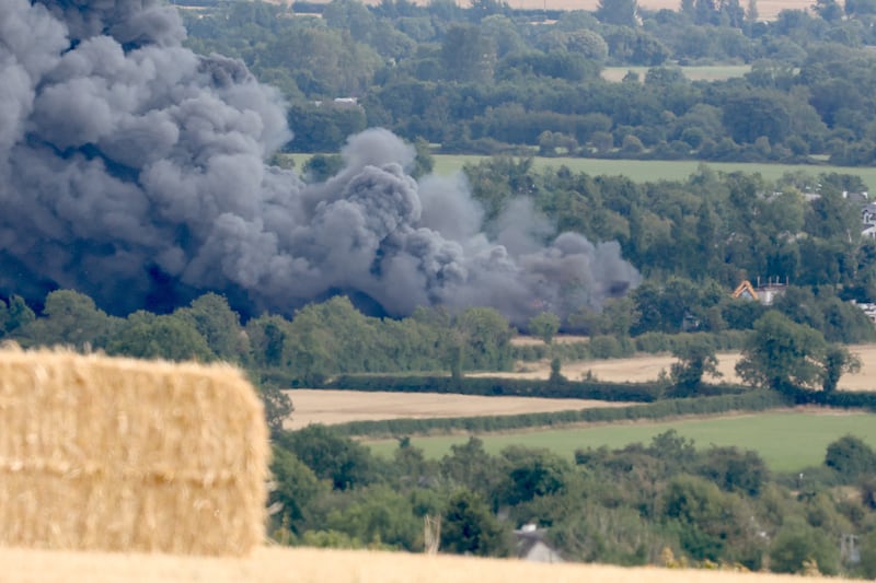 Black smoke drifts from the scene of the fire. Photograph: Garrett White/Collins