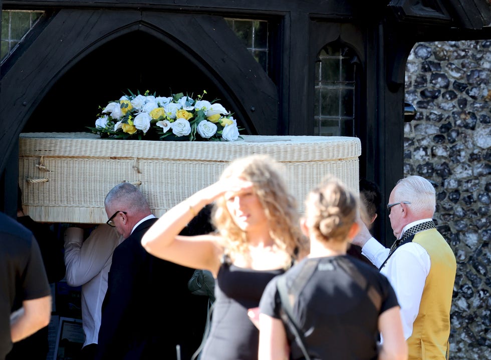 a cream coloured coffin being carried in eastenders during filming of funeral scenes