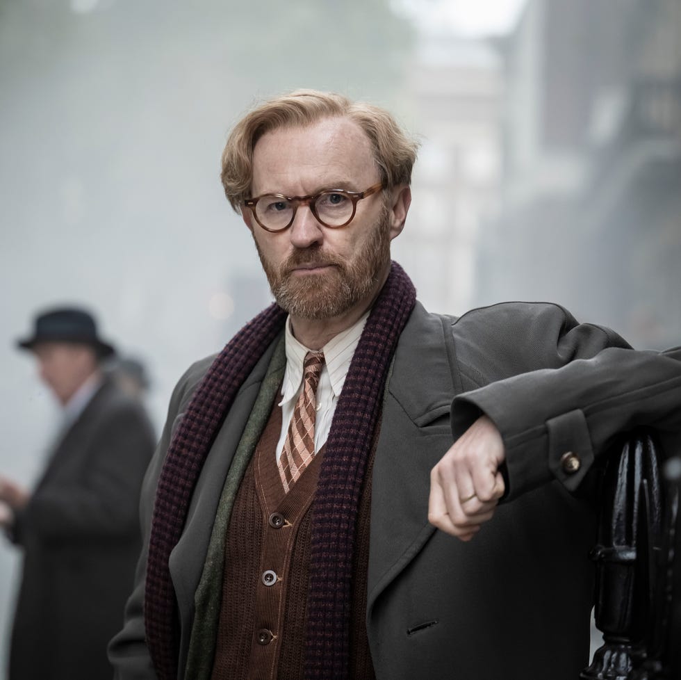 man with glasses and beard in vintage coat and scarf, standing on a misty street. man with glasses and beard in vintage coat and scarf, standing on a misty street.