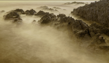 Titan's air warms the surface and its sky cools it: the greenhouse effect adds about 38 degrees Fahrenheit while the high-altitude haze subtracts about 16, leaving the surface about 22 degrees warmer than Titan's effective temperature