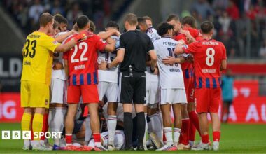 Bayern Munich and Heidenheim players surround Jamal Musiala following his collapse during a pre-season friendly on 18 August 2026