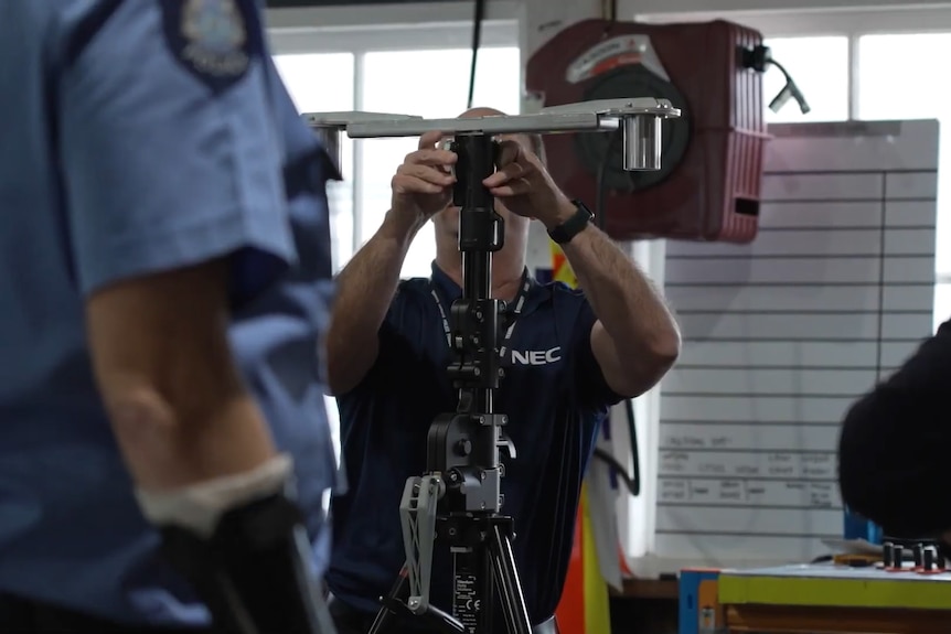 NEC tehnicician working on the surveillance set up with police.
