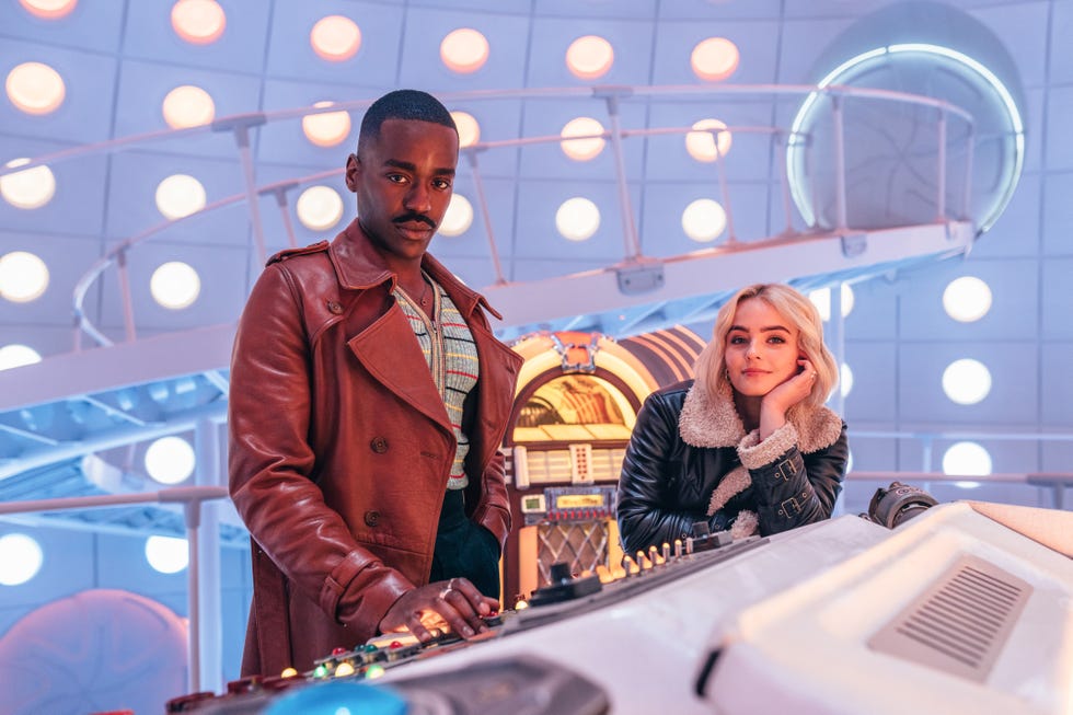 Doctor Who - Ncuti Gatwa and Millie Gibson in the TARDIS doctor who stars ncuti gatwa and millie gibson in the tardis, with the doctor's diner style jukebox in the background behind them