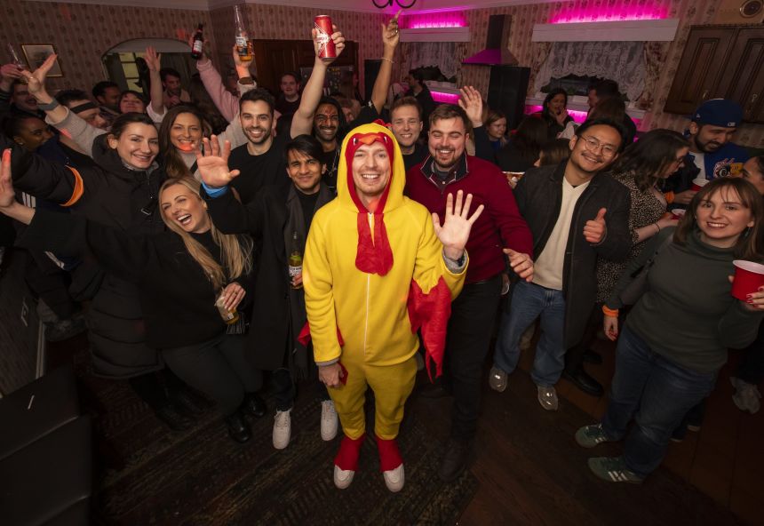 Chicken Rush staff dressed as a chicken poses with participating singles after the race.