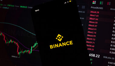 In this photo illustration, an iPhone displays the app and logo of popular cryptocurrency exchange platform Binance, with the desktop version in the background displaying market trends and exchange rates for cryptocurrency Bitcoin on 8th March, 2022 in Leeds, United Kingdom. (photo by Daniel Harvey Gonzalez/In Pictures via Getty Images)