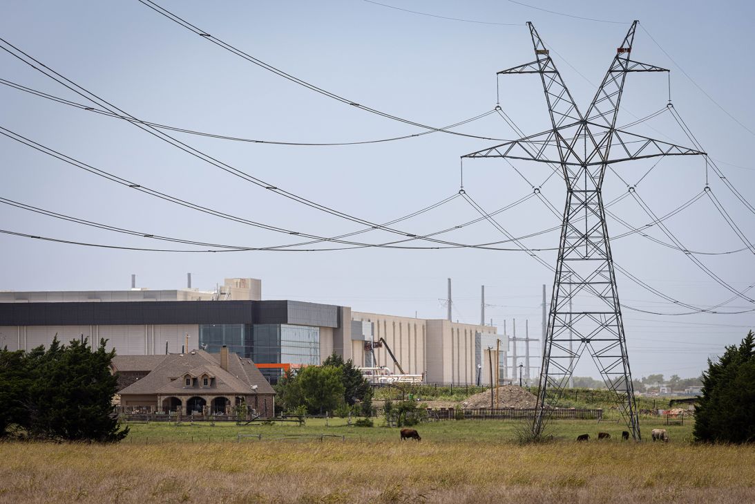 An unfinished data center campus and substation is seen behind a home along Stainback Road in Red Oak, Wednesday, June 24, 2026. Transmission lines carry power across a field that is for sale in the foreground. With one operational, three under construction and three more proposed, Red Oak will be home to seven data centers.