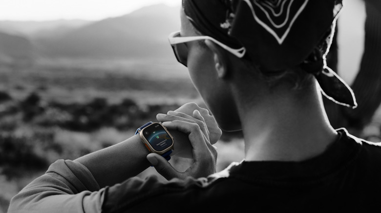 Apple Watch user tapping into satellite connection on Ultra 3 model.