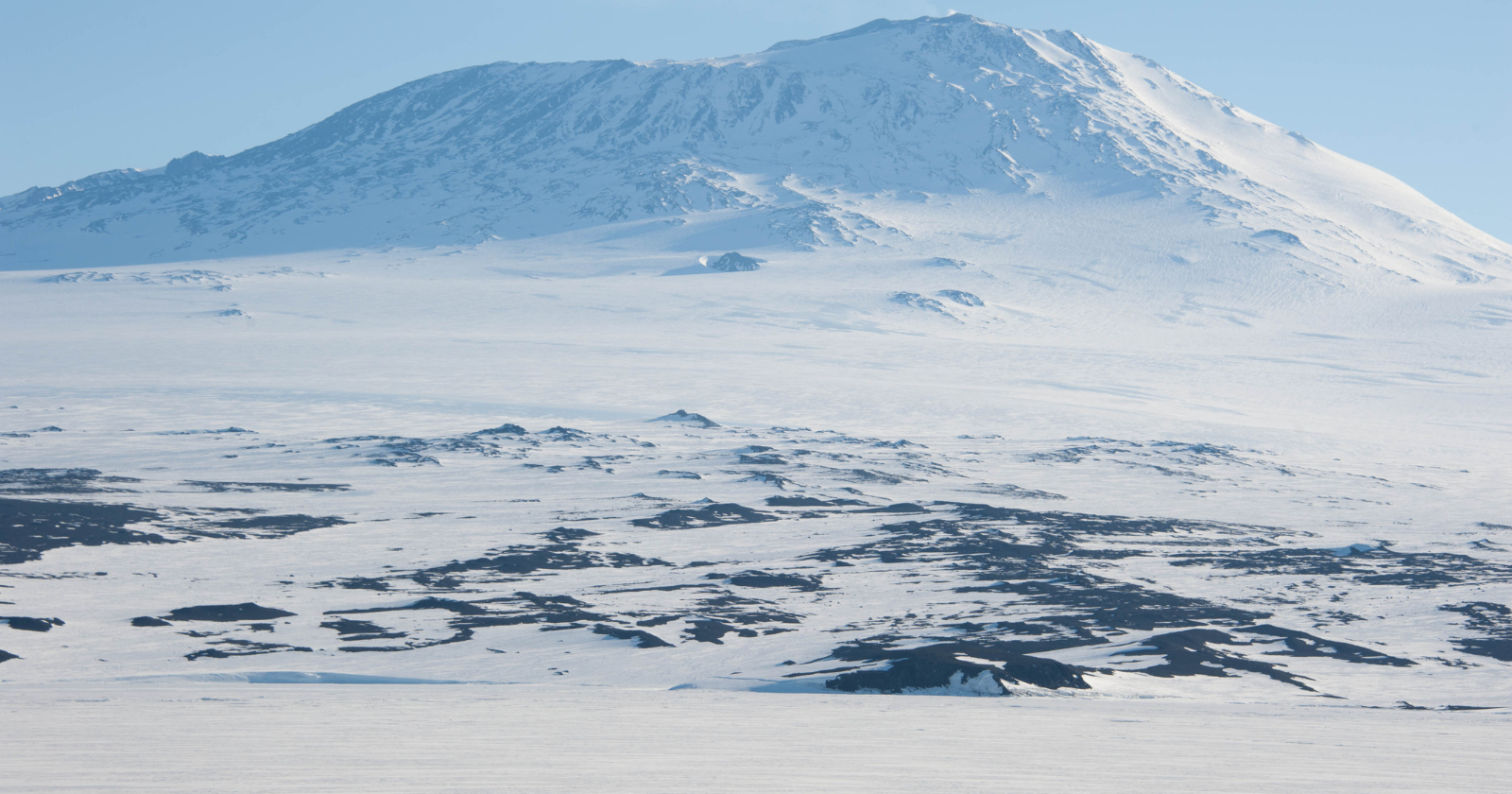 More than 45,000 meteorites have been collected from Antarctica, not because more fall there, but because flowing ice carries dark rocks into blue-ice stranding zones while the wind strips away snow, concentrating pieces of the Moon, Mars and asteroids on one enormous white surface