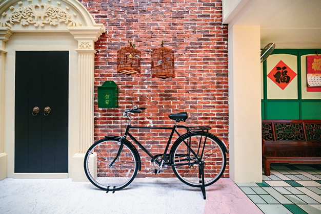 A bicycle leans against the iconic red brick walls of the shikumen.
