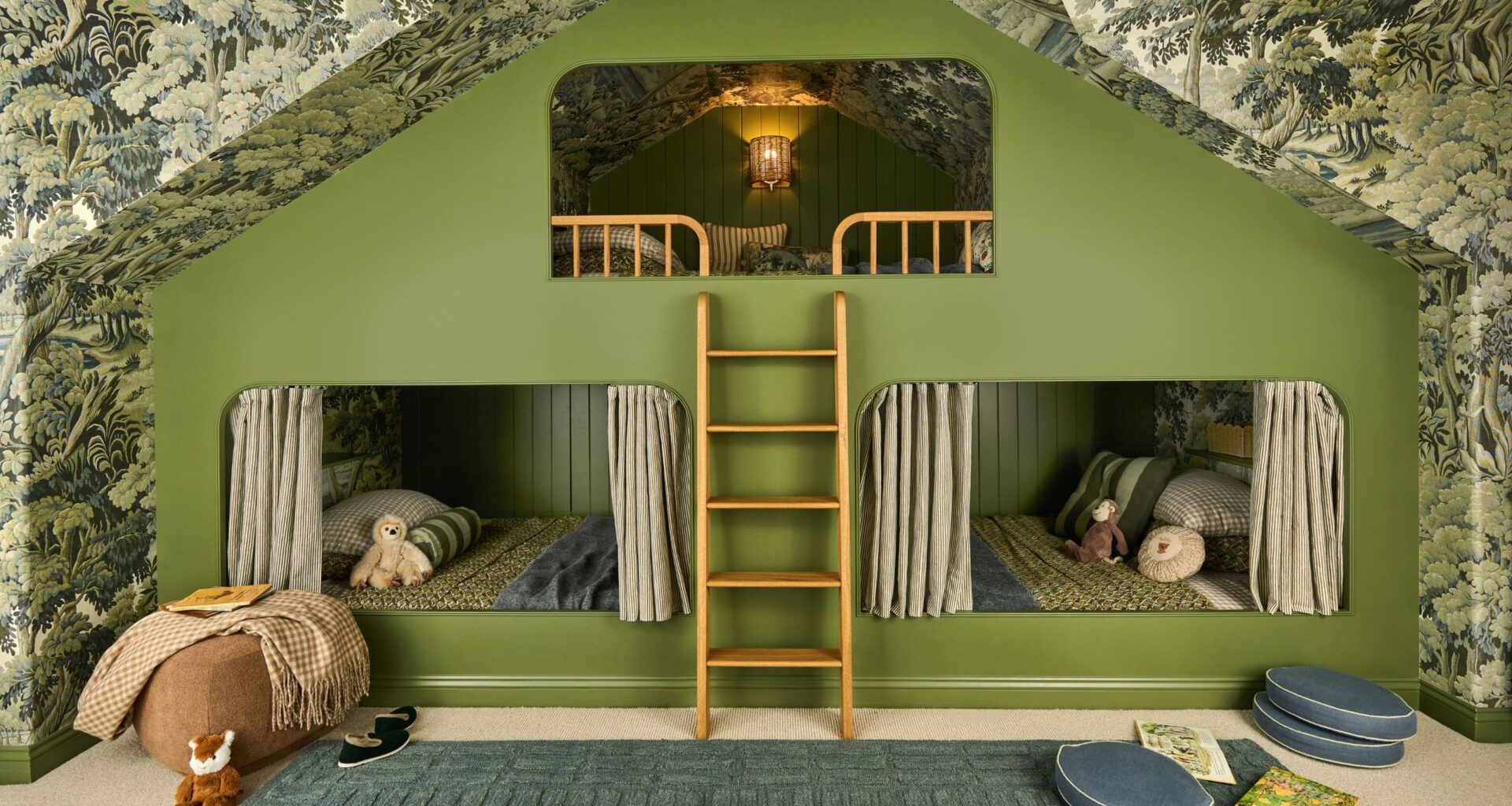 a vaulted attic room with tree wallpaper across walls and ceiling with a custom green painted triple bunk bed for kids