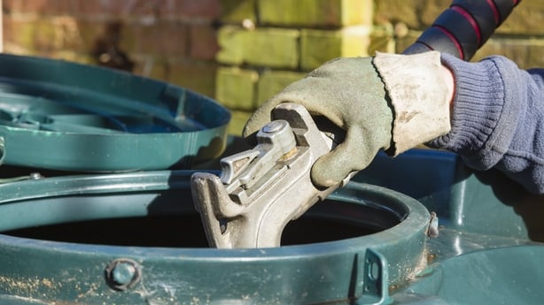 Closeup of man filling a bunded oil tank with domestic heating oil.