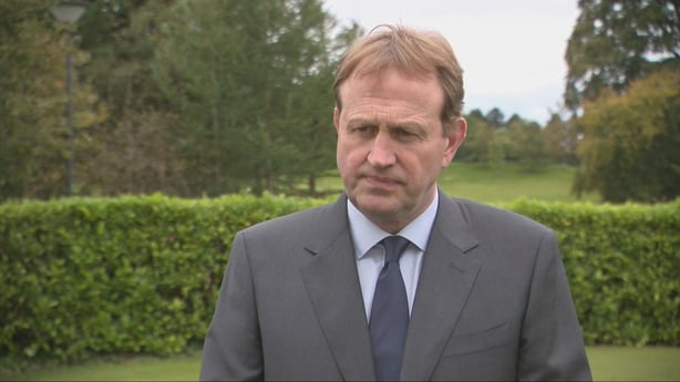 Minister for Justice Jim OCallaghan standing in front of a hedge.