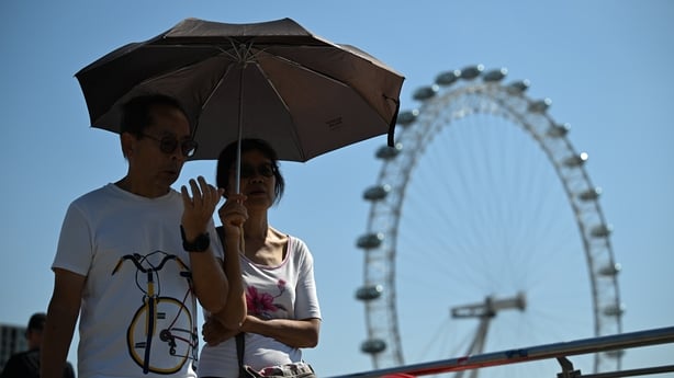 getty People use umbrellas to protect themselves from the sun during English heatwave last month