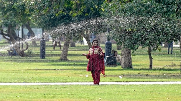 Visitors cool off at Kartavya Path in New Delhi, India