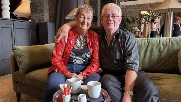 Cecilly and Albert Lawlor sit on a couch.