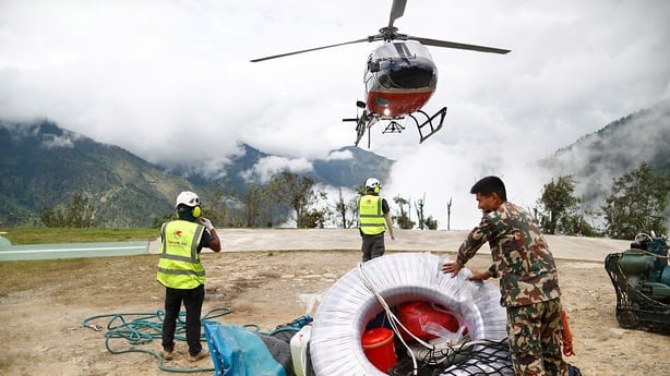 A helicopter prepares to carry materials for rescue efforts at the army barracks at Dunche in Rasuwa district