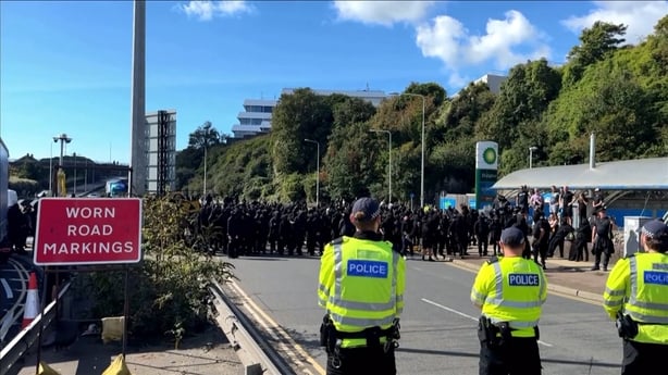 Men dressed all in black with UK police officers