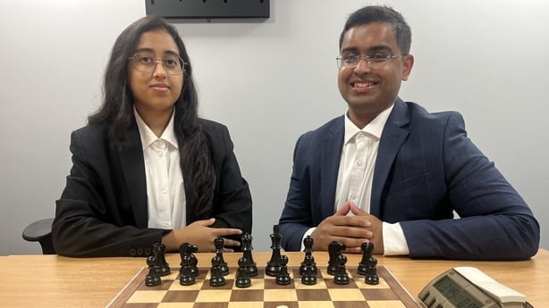Chess-playing siblings Trisha and Tarun Kanyamarala are seen in front of a chess board