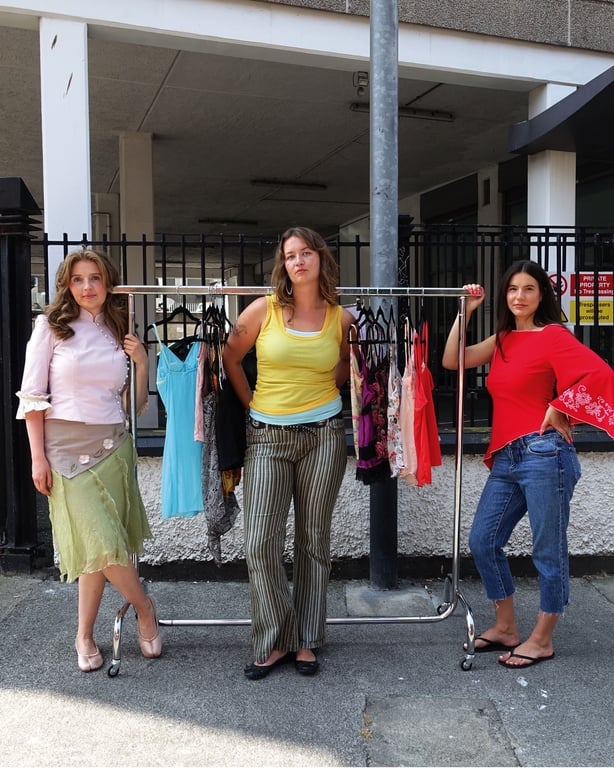 Three people with vintage clothes rails